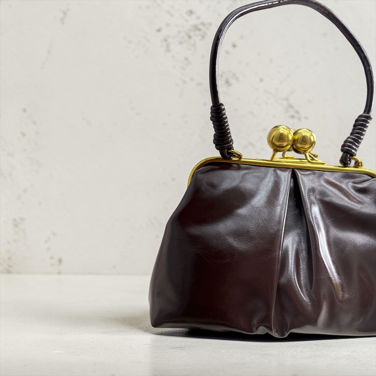 Pochette da donna in ecopelle semilucida con chiusura vintage a scatto e tracolla